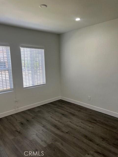 unfurnished room featuring dark hardwood / wood-style flooring and plenty of natural light