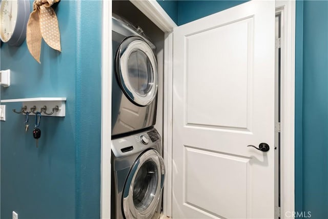 clothes washing area featuring stacked washer and dryer