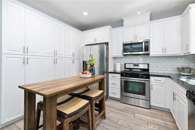 kitchen featuring white cabinets, backsplash, and stainless steel appliances