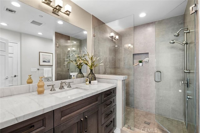 bathroom featuring tile patterned flooring, vanity, and walk in shower