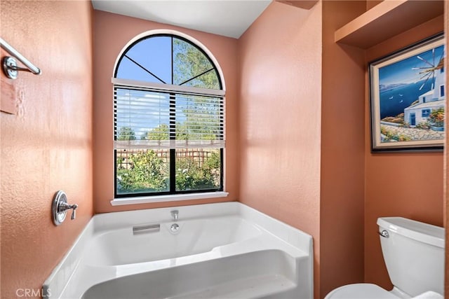 bathroom with toilet and a bath