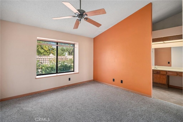 carpeted spare room featuring ceiling fan, a textured ceiling, and vaulted ceiling