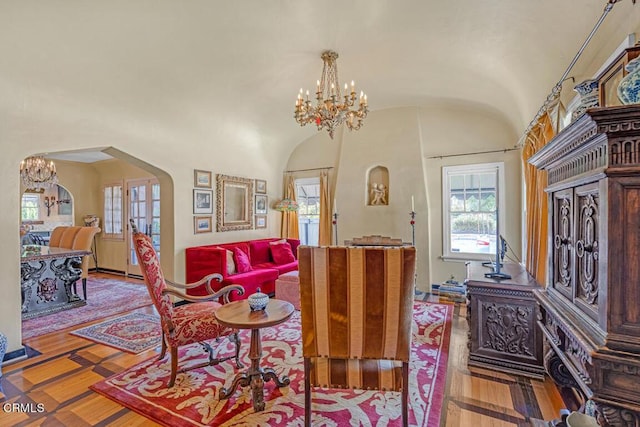 living room with lofted ceiling, light hardwood / wood-style flooring, and an inviting chandelier