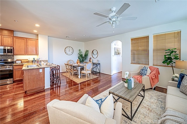 living room with ceiling fan, sink, and dark hardwood / wood-style flooring