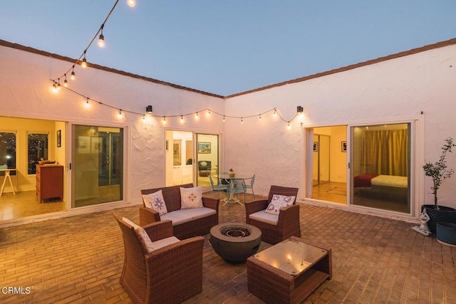 patio terrace at dusk featuring an outdoor living space with a fire pit