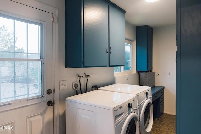 clothes washing area with cabinets and washing machine and clothes dryer