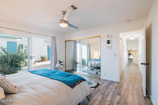 bedroom featuring hardwood / wood-style flooring, ceiling fan, access to exterior, and a closet