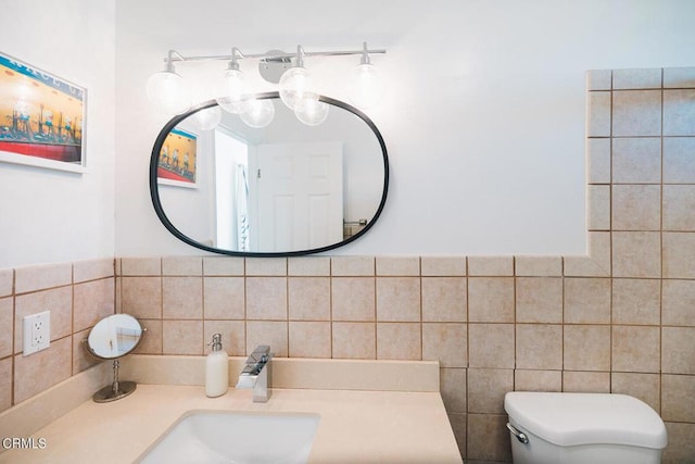 bathroom with vanity, tile walls, and toilet