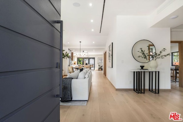 hall featuring an inviting chandelier and light hardwood / wood-style floors