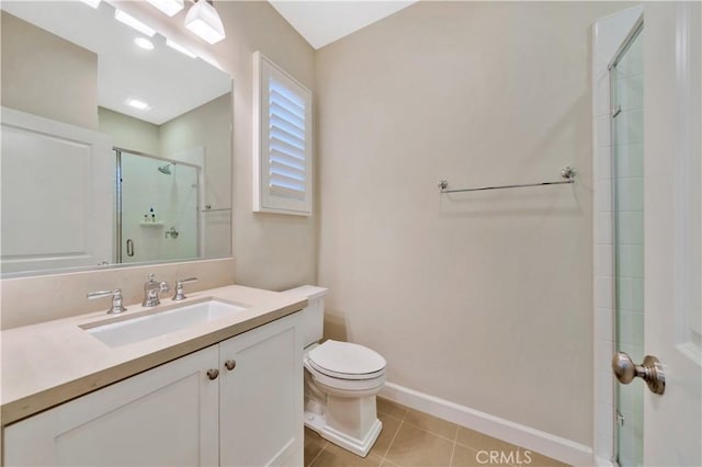 bathroom with vanity, toilet, tile patterned floors, and a shower with shower door