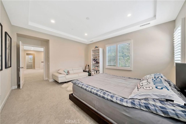 carpeted bedroom featuring a raised ceiling