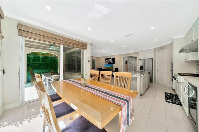 dining room with light tile patterned floors and crown molding