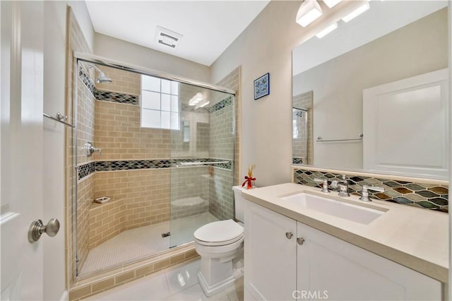 bathroom with a shower with door, backsplash, vanity, tile patterned floors, and toilet