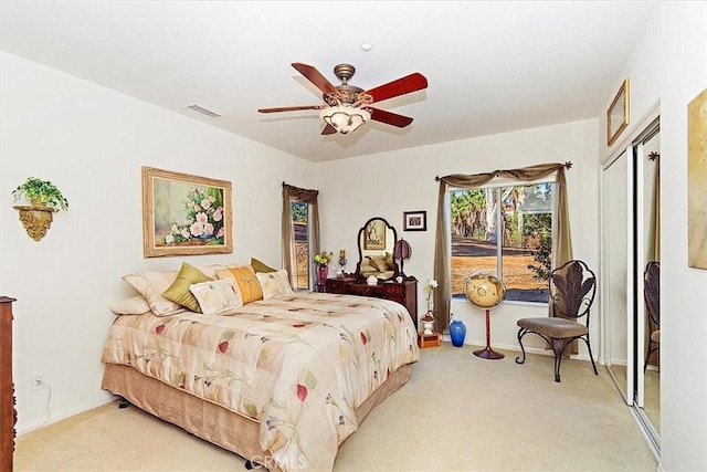 carpeted bedroom with ceiling fan and a closet