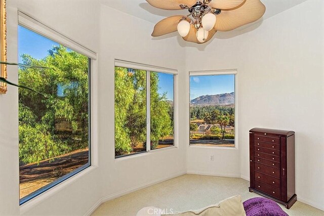 unfurnished sunroom featuring ceiling fan