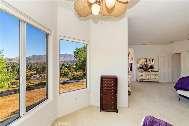 carpeted bedroom featuring multiple windows, a mountain view, and ceiling fan