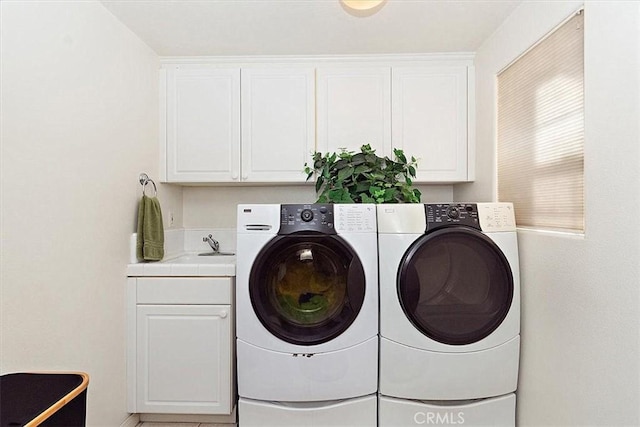 washroom with cabinets, independent washer and dryer, and sink