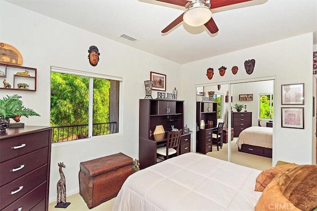 bedroom featuring ceiling fan, light carpet, and a closet