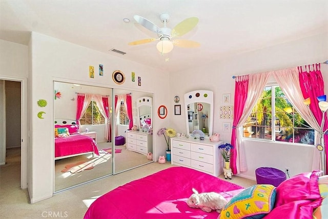 carpeted bedroom featuring ceiling fan and a closet