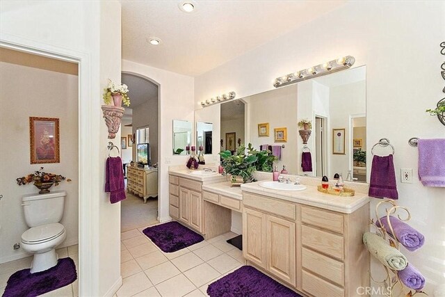 bathroom featuring tile patterned flooring, vanity, and toilet