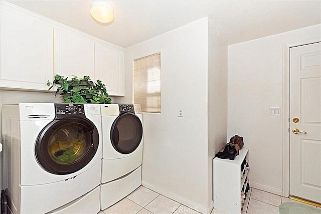 washroom with separate washer and dryer, light tile patterned floors, and cabinets