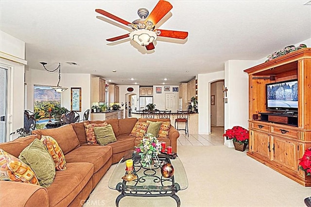 carpeted living room with ceiling fan