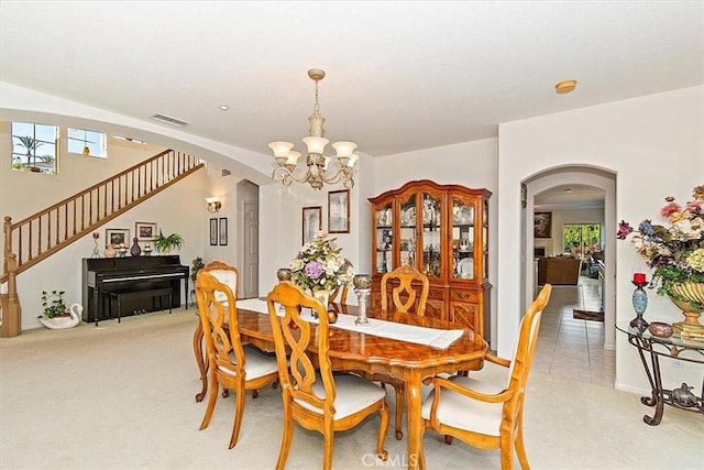 carpeted dining area with a notable chandelier