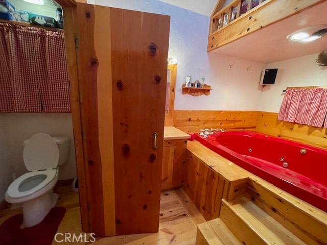 bathroom featuring wood-type flooring, a bathtub, and toilet