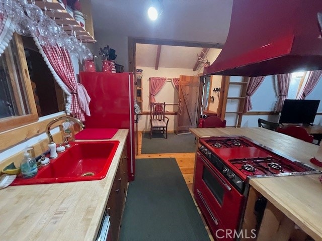 kitchen with light wood-type flooring, range, and sink