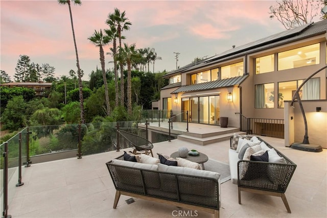 exterior space with solar panels, an outdoor living space, and a patio area