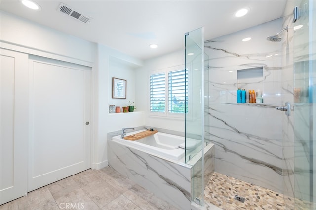 bathroom featuring shower with separate bathtub