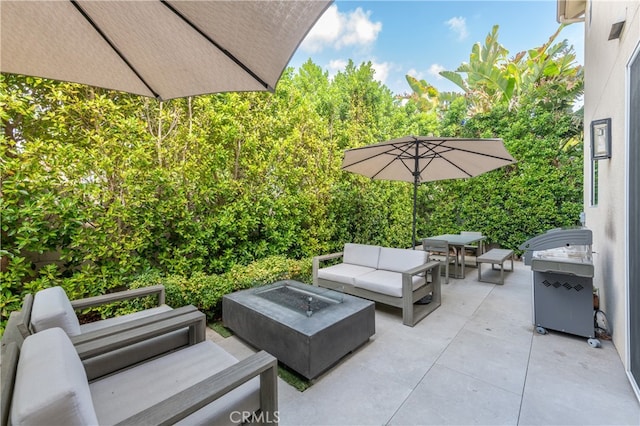 view of patio / terrace with area for grilling and an outdoor living space with a fire pit