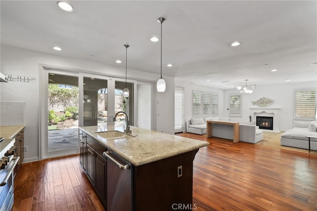 kitchen featuring a healthy amount of sunlight, dark hardwood / wood-style flooring, sink, and a kitchen island with sink