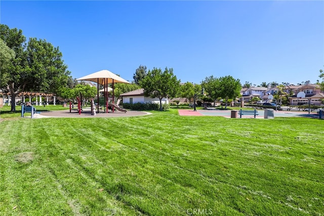 view of home's community featuring a playground and a yard