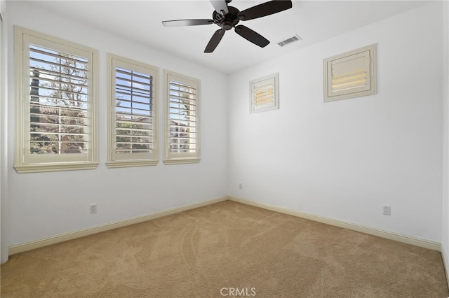 unfurnished room featuring plenty of natural light, ceiling fan, and light carpet