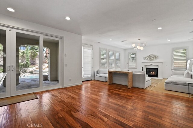 unfurnished living room featuring hardwood / wood-style floors and a chandelier