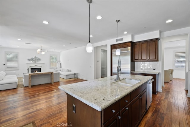 kitchen with a healthy amount of sunlight, sink, stainless steel appliances, and a kitchen island with sink