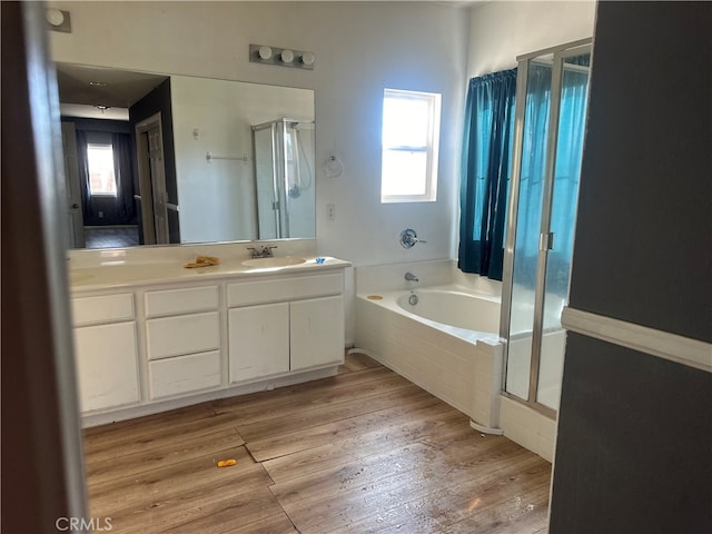 bathroom featuring a healthy amount of sunlight, vanity, wood-type flooring, and shower with separate bathtub