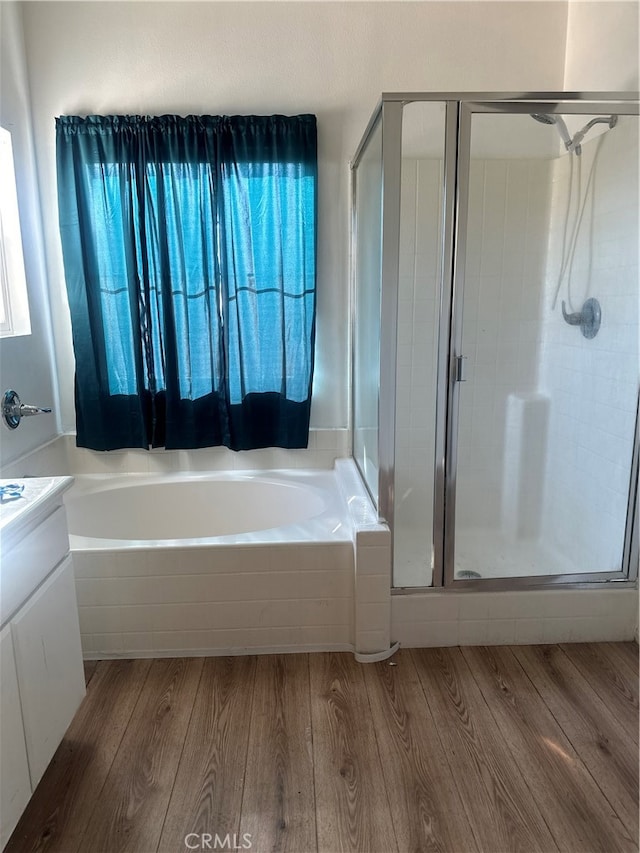 bathroom with shower with separate bathtub, vanity, and hardwood / wood-style flooring