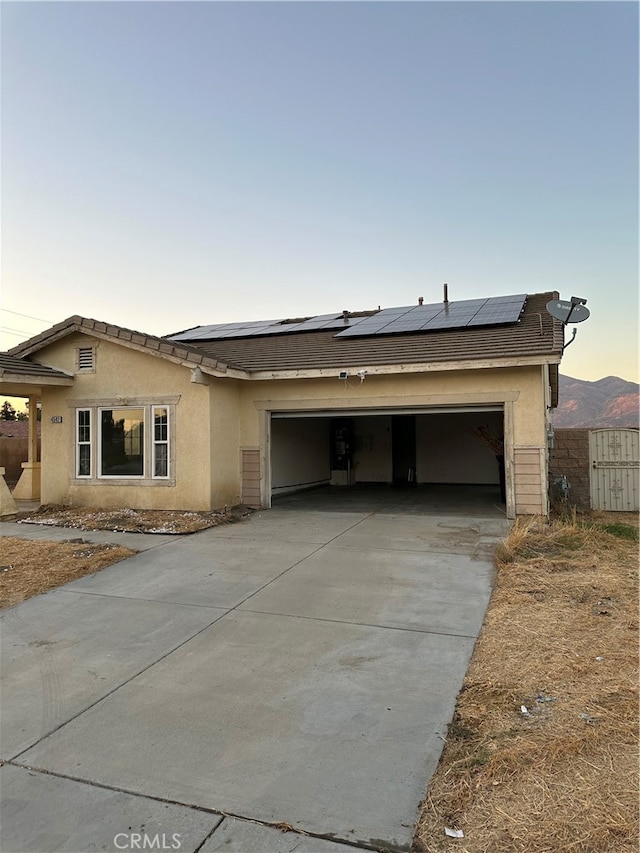 view of front of home with a mountain view, a garage, and solar panels