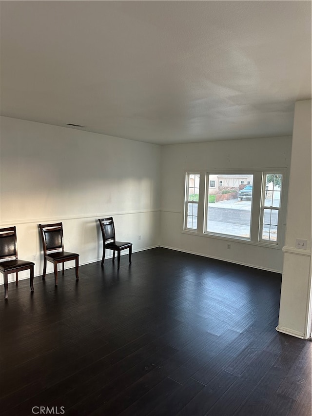 unfurnished room with dark hardwood / wood-style flooring