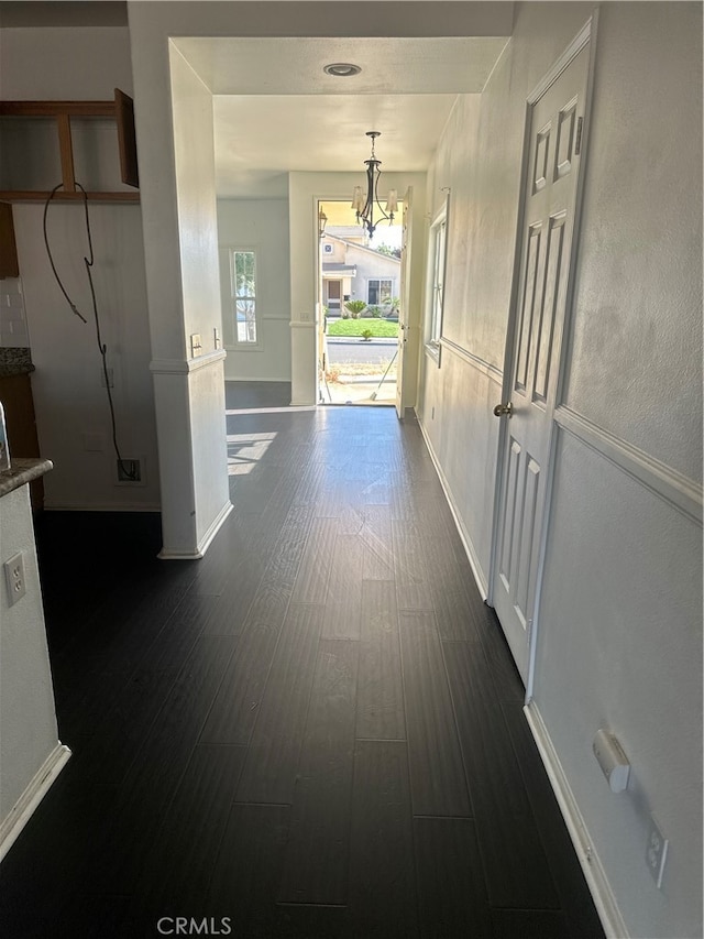 hall with an inviting chandelier and dark hardwood / wood-style floors