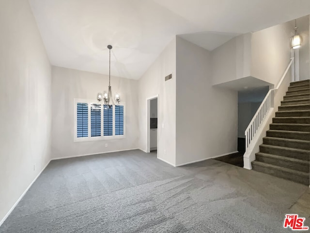 interior space featuring an inviting chandelier, dark carpet, and high vaulted ceiling