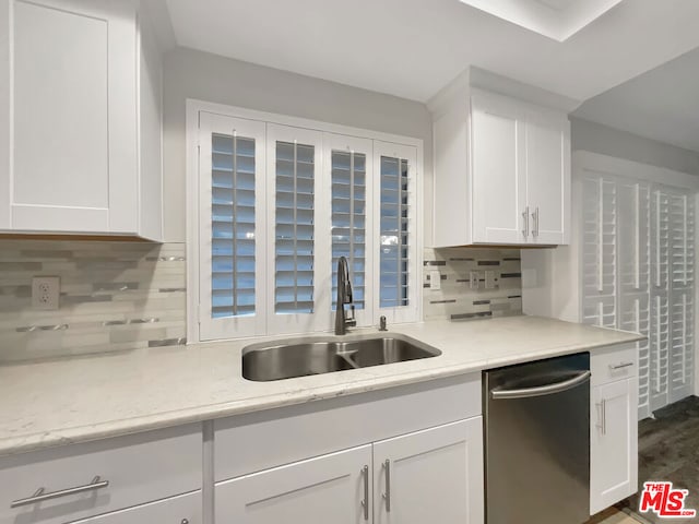 kitchen featuring dishwasher, sink, tasteful backsplash, and white cabinetry