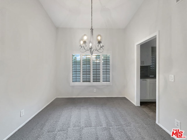 unfurnished room with a notable chandelier and carpet floors