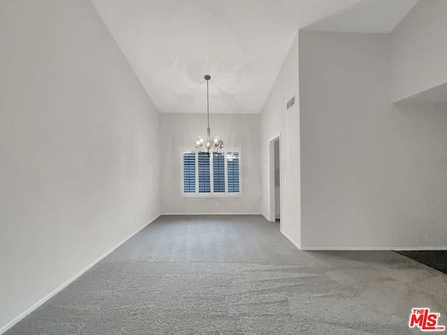 unfurnished dining area with a notable chandelier, high vaulted ceiling, and carpet flooring