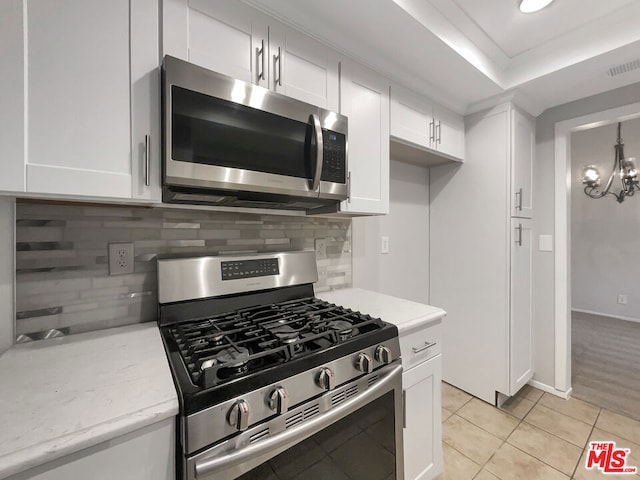 kitchen featuring white cabinets, stainless steel appliances, and light tile patterned floors