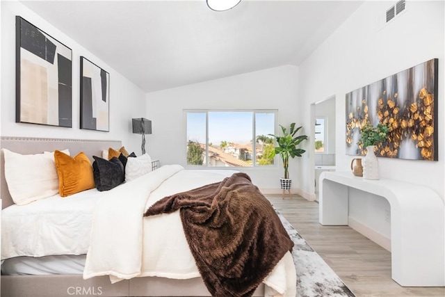 bedroom featuring light hardwood / wood-style floors and lofted ceiling