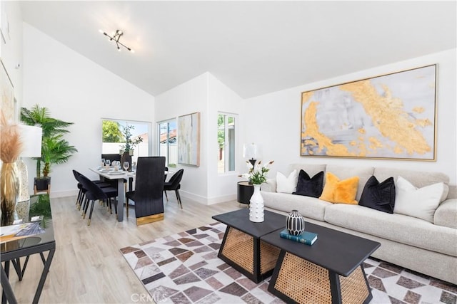 living room with light hardwood / wood-style floors and high vaulted ceiling