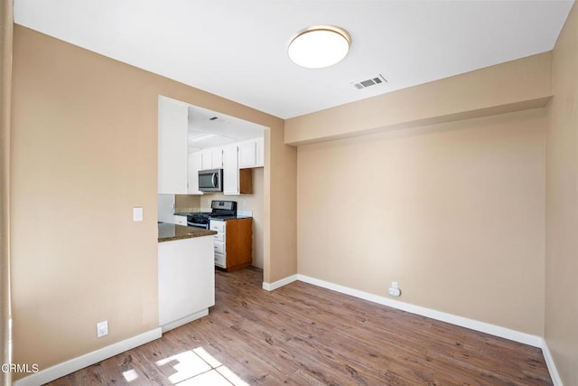 kitchen featuring white cabinetry, light wood-type flooring, and appliances with stainless steel finishes